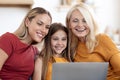 Happy family mother, daughter and grandmother using laptop at home Royalty Free Stock Photo