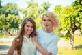 Happy family. mother and daughter looking at you camera smiling isolated outdoors outside park background Royalty Free Stock Photo