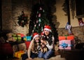 Family on Christmas eve. Mother and daughter and dog with Xmas presents. Family with gift boxes. Living room with decorated tree. Royalty Free Stock Photo