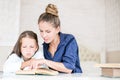 Happy family mother and daughter read a book in the evening at home. the concept of family comfort and family relations Royalty Free Stock Photo