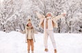 Happy family mother and daughter rejoicing first snow in snowy winter park Royalty Free Stock Photo