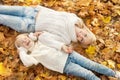 Happy family mother and daughter relax laying on maple leaves in autumn park Royalty Free Stock Photo