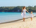 Happy family mother and daughter run, laugh and play at beach Royalty Free Stock Photo