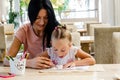 A happy family. Mother and daughter smiling together with colored pencils at the table Royalty Free Stock Photo