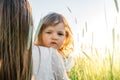 Happy family, mother in a dress with a cute little baby on a golden wheat field at sunset. summer day Royalty Free Stock Photo