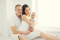 Happy family, mother and father with baby home in white room Royalty Free Stock Photo