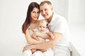 Happy family mother and father with baby at home in white room Royalty Free Stock Photo
