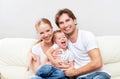 Happy family mother, father, child baby daughter at home on sofa playing and laughing Royalty Free Stock Photo