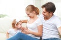 Happy family mother, father, child baby daughter at home on sofa playing and laughing Royalty Free Stock Photo