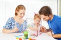 Happy family: mother, father and child daughter draw paints Royalty Free Stock Photo