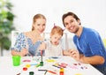 Happy family: mother, father and child daughter draw paints Royalty Free Stock Photo