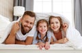 Happy family mother, father and child  laughing, playing and smiling in bed   at home Royalty Free Stock Photo