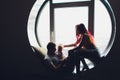 happy family of mother, father and child son playing and cuddling at home on floor near a big window. Royalty Free Stock Photo