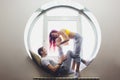 happy family of mother, father and child son playing and cuddling at home on floor near a big window. Royalty Free Stock Photo