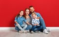 Happy family mother father and children daughter and son  near an   red wall Royalty Free Stock Photo