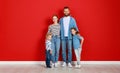 Happy family mother father and children daughter and son  near an   red wall Royalty Free Stock Photo