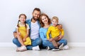 Happy family mother father and children daughter and son  near an   grey blank wall Royalty Free Stock Photo