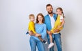 Happy family mother father and children daughter and son  near an   grey blank wall Royalty Free Stock Photo