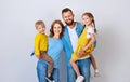 Happy family mother father and children daughter and son  near an   grey blank wall Royalty Free Stock Photo