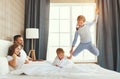 Happy family mother, father and children laughing, playing and jumping in bed   at home Royalty Free Stock Photo