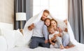 Happy family mother, father and children laughing, playing and smiling in bed   at home Royalty Free Stock Photo