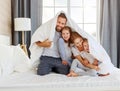 Happy family mother, father and children laughing, playing and smiling in bed   at home Royalty Free Stock Photo