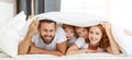 Happy family mother, father and children laughing, playing and smiling in bed   at home Royalty Free Stock Photo