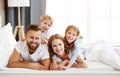 Happy family mother, father and children laughing, playing and smiling in bed   at home Royalty Free Stock Photo