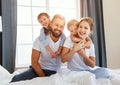 Happy family mother, father and children laughing, playing and smiling in bed   at home Royalty Free Stock Photo