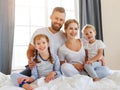 Happy family mother, father and children laughing, playing and smiling in bed   at home Royalty Free Stock Photo