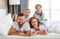 Happy family mother, father and children laughing, playing and smiling in bed   at home Royalty Free Stock Photo