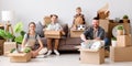 Happy family mother father and children move to new apartment and look at the camera while unpacking the boxes Royalty Free Stock Photo