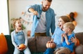 Happy family mother father and children prepare for Halloween decorate home with pumpkins and laughing, play and scare with