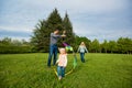 Happy family.Mother, father, children running over a green mead Royalty Free Stock Photo