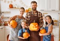 Happy family mother, father and kids smiling at camera make jack-o-lantern from pumpkin, getting ready for halloween Royalty Free Stock Photo