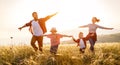 Happy family: mother, father, children son and daughter runing and jumping on sunset Royalty Free Stock Photo