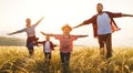 Happy family: mother, father, children son and daughter runing and jumping on sunset Royalty Free Stock Photo