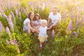 Happy family mother father embracing kids outdoor. Woman man baby child and teenage girl sitting on summer field with Royalty Free Stock Photo