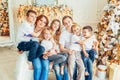 Happy family mother father five children relax playing near Christmas tree on Christmas eve at home. Mom dad daughter son in light Royalty Free Stock Photo