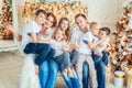Happy family mother father five children relax playing near Christmas tree on Christmas eve at home. Mom dad daughter Royalty Free Stock Photo