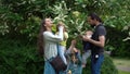 Happy family mother Father four Baby little siblings kids have fun sniffing flowers on trees enjoying summer holidays in Royalty Free Stock Photo