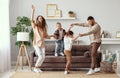 Happy family mother father and children dancing at home