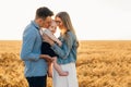 Happy family, mother, father and little child on the ripe wheat field Royalty Free Stock Photo