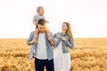 Happy family, mother, father and little child on the ripe wheat field Royalty Free Stock Photo