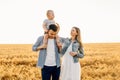 Happy family, mother, father and little child on the ripe wheat field Royalty Free Stock Photo