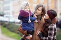 Happy Family - mother, father and little girl walking in autumn city and having fun Royalty Free Stock Photo