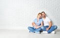 happy family mother, father of a newborn baby on floor near blank wall Royalty Free Stock Photo