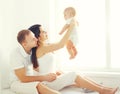 Happy family, mother and father playing with baby home in white room Royalty Free Stock Photo