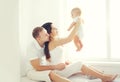 Happy family, mother and father playing with little baby home in white room near window Royalty Free Stock Photo