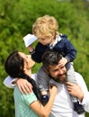 Happy family - mother, father and son on sky background in summer. Happy family - child son playing with paper airplane Royalty Free Stock Photo